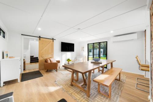a living room with a wooden table and a dining room at The Dingaling - Beach House Bliss with Firepit & BBQ in Aldinga Beach