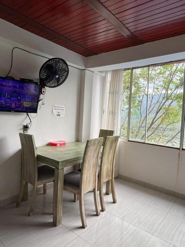 a dining room table with chairs and a clock on the wall at Apartamento mirador 1 in Melgar