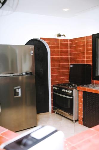 a kitchen with a stainless steel refrigerator and a stove at Modern villa with pool views in Ngaparou