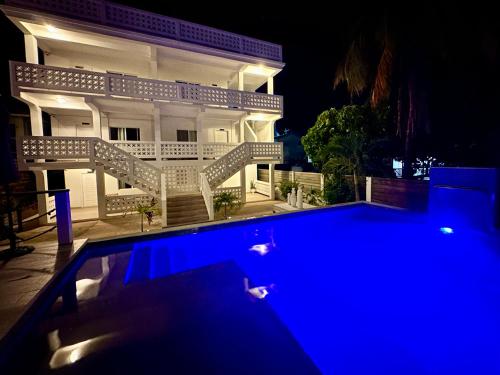 a swimming pool in front of a house at night at Treetops Hotel in Caye Caulker