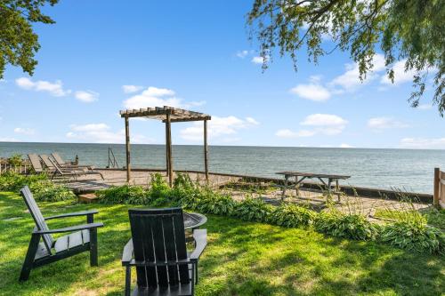 a group of chairs sitting on the grass near the ocean at Birds Eye View on Erie with Hot Tub & Game Room in Leamington