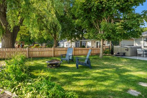 a yard with two chairs and a table and a fence at Birds Eye View on Erie with Hot Tub & Game Room in Leamington