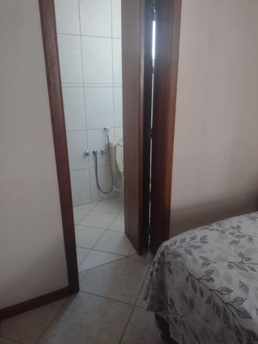 a bathroom with a shower and a bed in a room at Apartamento à uma quadra da praia in Torres