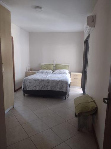 a bedroom with a bed and a tiled floor at Apartamento à uma quadra da praia in Torres