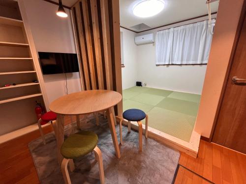 a small table and two stools in a room at にじいろ邸東京大島駅前 in Tokyo