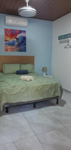a bedroom with a bed with a painting on the wall at Loft en surf city in Tamanique