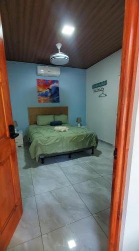 a bedroom with a bed in a blue room at Loft en surf city in Tamanique
