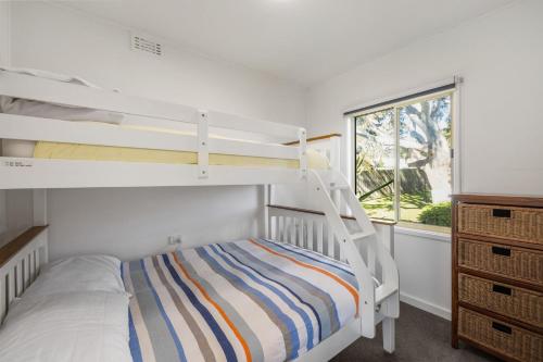 une chambre avec un lit superposé et une échelle dans l'établissement Anmere Cottage, à Ventnor