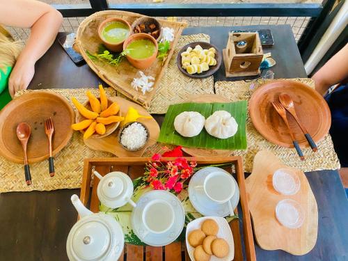 a table topped with plates and bowls of food at Zensigiri Ayurveda Wellness Homestay in Sigiriya