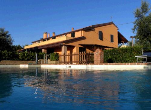 a house sitting on top of a body of water at Agriturismo Colomboni in San Costanzo