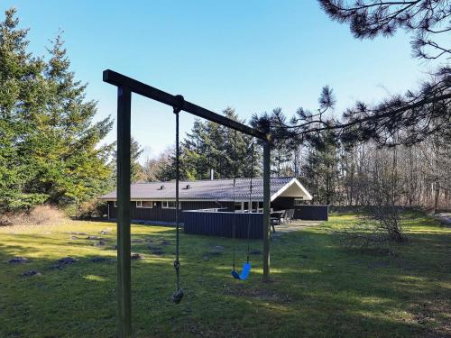 a swing in a yard with a house at 6 person holiday home in Fjerritslev-By Traum in Fjerritslev