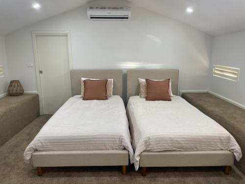 two beds sitting next to each other in a room at Waterfront Double-Cabin Getaway in Wisemans Ferry
