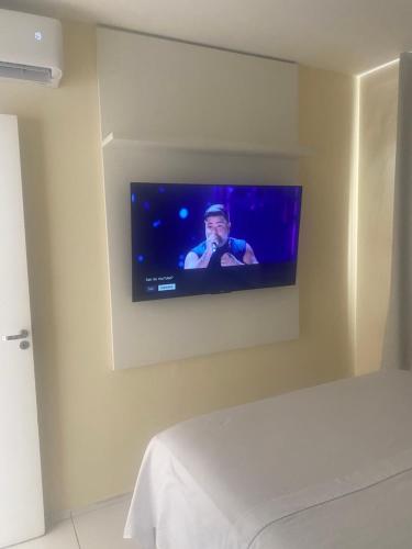 a television hanging on a wall in a bedroom at Apto 2 quartos com ar - Fechadura eletrônica - Até 8 pessoas in Petrolina