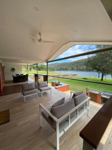 a living room with couches and a large window at Waterfront Double-Cabin Getaway in Wisemans Ferry