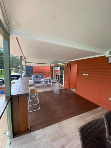 an open living room with red walls and wooden floors at Waterfront Double-Cabin Getaway in Wisemans Ferry