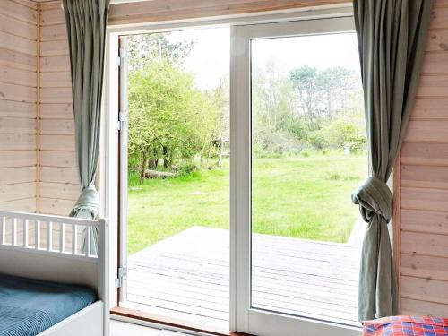 a sliding glass door in a bedroom with a porch at 6 person holiday home in Nykøbing Sj-By Traum in Klint