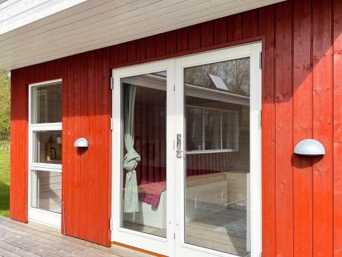 a red house with a white door and windows at 6 person holiday home in Nykøbing Sj-By Traum in Klint