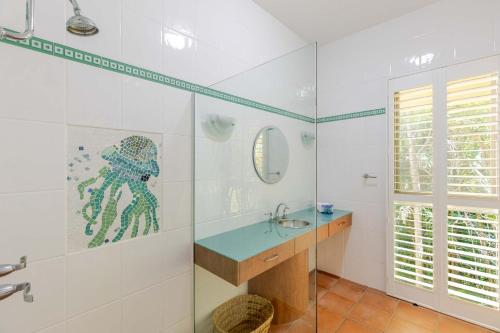 a bathroom with a sink and a glass shower at The Hill Villa 2 in Port Douglas