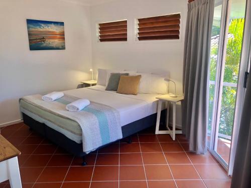 un dormitorio con una cama y una ventana en Beaches No 6 - Beachfront Views, en South Mission Beach