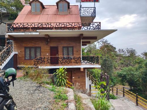 a house with a red roof and a balcony at The Royal Summit, Panchalimedu in Suryanelli