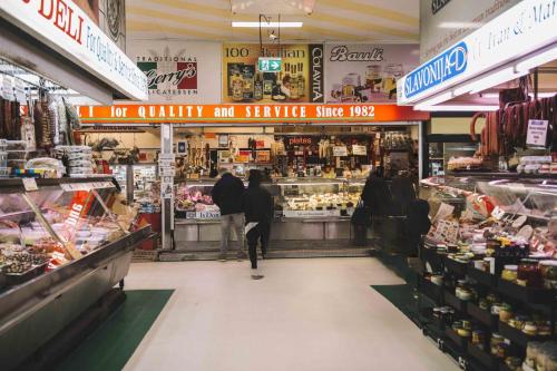 a group of people walking through a supermarket aisle at Elevated Escape - 2BR w Gym & Rooftop Spa in Melbourne