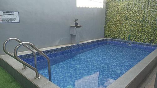 a large swimming pool with blue tiles in a building at Villa Pondok Kelapa Batu in Batu