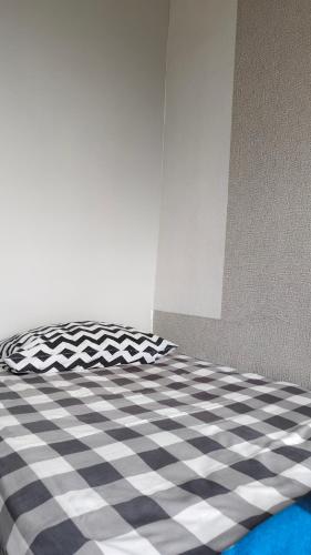 a bed with a black and white checkered floor at Villa Pondok Kelapa Batu in Batu