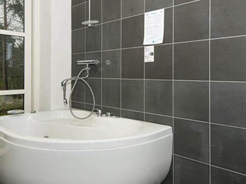 a bathroom with a bath tub and a sink at 10 person holiday home in Ebeltoft-By Traum in Ebeltoft