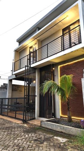 a building with a palm tree in front of it at Villa Pondok Kelapa Batu in Batu