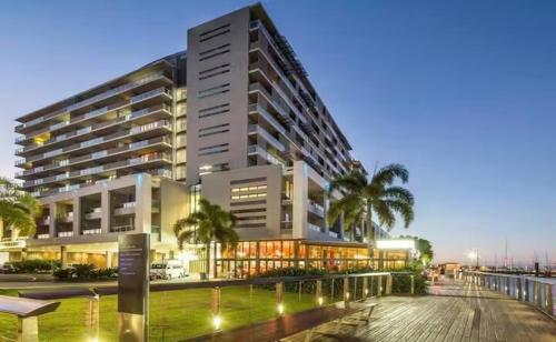 Un gran edificio con palmeras delante. en Parkview Studio at Harbour Lights, en Cairns