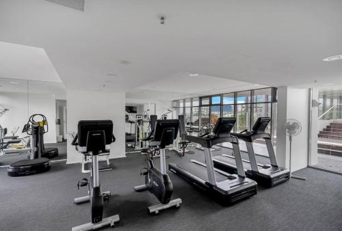 un gimnasio con varias bicicletas estáticas y cintas de correr en Parkview Studio at Harbour Lights, en Cairns