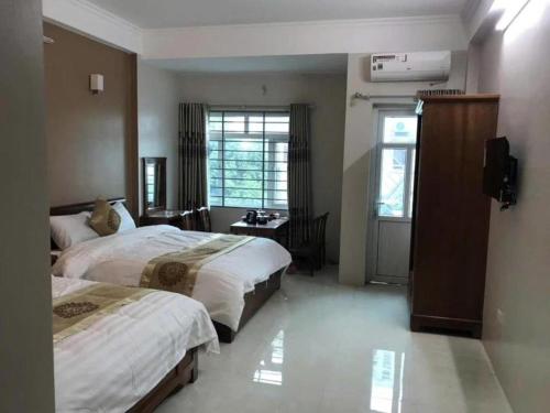 a hotel room with two beds and a window at Love Hotel in Hanoi