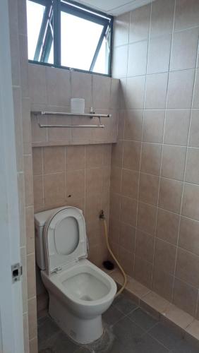a small bathroom with a toilet and a window at DongDong2 in Kuching