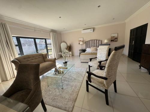 a living room with a couch and chairs at Orkney Villa in Klerksdorp