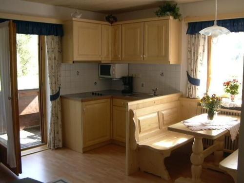 a kitchen with yellow cabinets and a table with a table sidx sidx sidx at Haus Hinterseer in Schneizlreuth