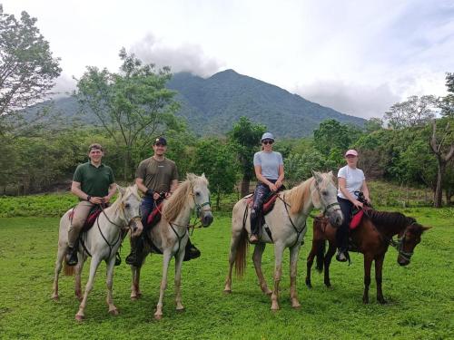 a group of people riding horses in a field at Finca Montaña Sagrada in Mérida