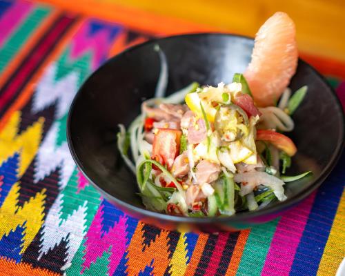a black bowl of food on a colorful table at Villa Sima - Tropical Elegance in central Panglao in Panglao