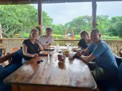 a group of people sitting around a wooden table at Finca Montaña Sagrada in Mérida