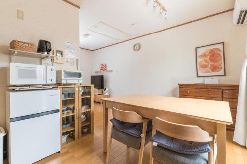 a kitchen with a wooden table and a refrigerator at Ken House Kyoto in Kyoto