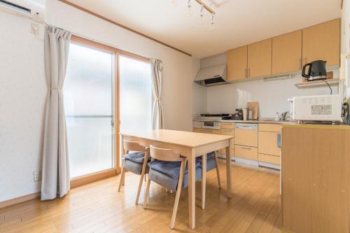 a kitchen with a wooden table and a window at Ken House Kyoto in Kyoto