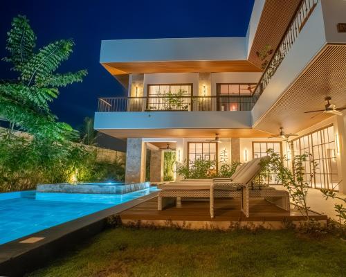 a villa with a swimming pool at night at Villa Sima - Tropical Elegance in central Panglao in Panglao