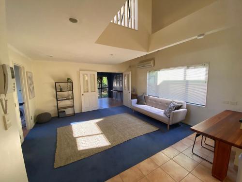 a living room with a couch and a table at The Blue Jem - A central city home away from home! in Napier