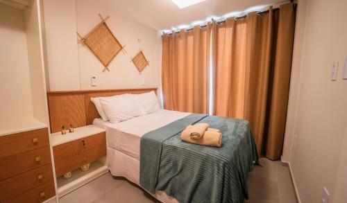 a small bedroom with a bed with a towel on it at Casa 12 do Paraíso - Atins in Atins