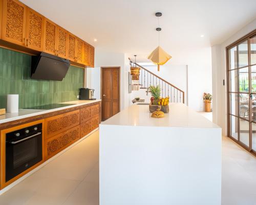 a kitchen with wooden cabinets and a white counter top at Villa Sima - Tropical Elegance in central Panglao in Panglao