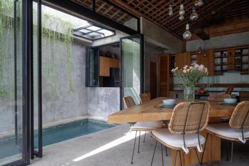 ein Esszimmer im Freien mit einem Holztisch und Stühlen in der Unterkunft Pritidaya Private Pool Villa Canggu by OXO in Munggu