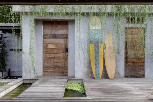 zwei Surfbretter, die an einer Wand neben einem Gebäude lehnen in der Unterkunft Pritidaya Private Pool Villa Canggu by OXO in Munggu