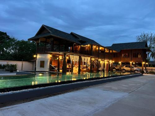 ein großes Haus mit einem davorliegenden Swimmingpool in der Unterkunft The Elephant House and Bungalows 