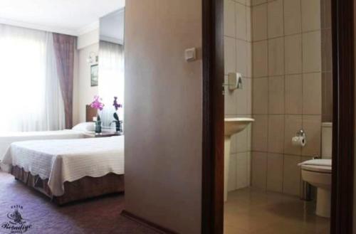 a bedroom with a bed and a bathroom with a sink at Fatih Resadiye Hotel in Istanbul