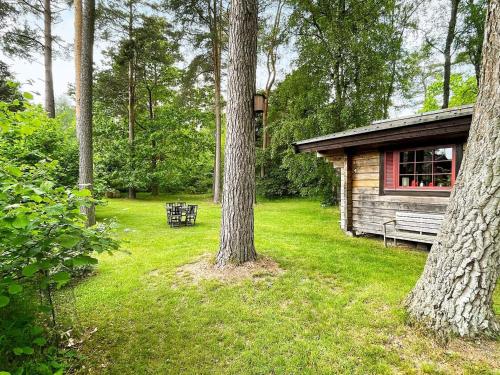 a log cabin with a bench next to a tree at 6 person holiday home in blentarp-By Traum in Blentarp