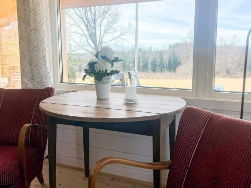 a table with a vase of flowers on it next to a window at 6 person holiday home in RÖRVIK in Rörvik